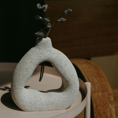 a vase with a plant near a wooden chair